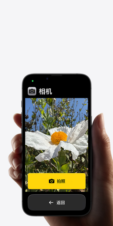 iPhone?16e 屏幕顯示精簡的相機 app 界面，包括取景畫面中的白色花朵、“拍照”按鈕及其下方的“返回”按鈕。