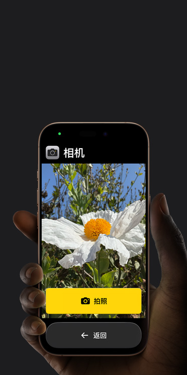 iPhone?16?Pro 屏幕顯示精簡的相機 app 界面，包括取景畫面中的白色花朵、“拍照”按鈕及其下方的“返回”按鈕。