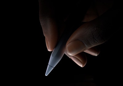 用戶用拇指和食指握住 Apple Pencil Pro 靠下三分之一左右的位置，做出書寫姿勢(shì)。