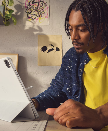 一位男子在辦公室使用銀色 12.9 英寸 iPad Pro。
