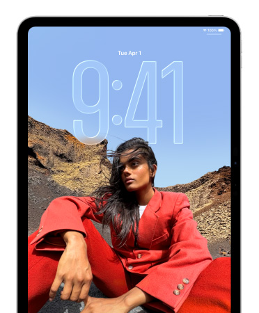 iPad 展示鎖定屏幕，其中表示時間的大型數(shù)字位于坐著的人物圖片后方。