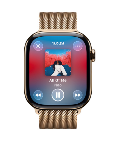 金色鈦金屬 Apple Watch 搭配米蘭尼斯表帶，表盤顯示 Apple Music 正在播放音樂，控制按鈕為半透明的 Liquid Glass 設(shè)計(jì)。