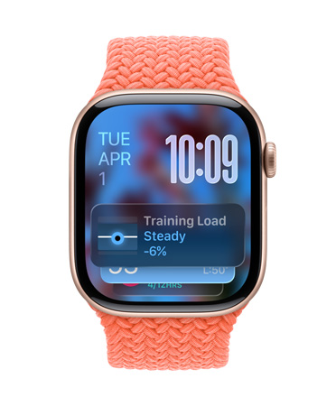 玫瑰金色 Apple Watch 搭配橘紅色編織表帶，表盤左上角顯示日期，右上角有數(shù)字顯示時間，下方為訓(xùn)練負(fù)荷小組件，全部采用半透明 Liquid Glass 設(shè)計(jì)。